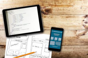 Website development, Wireframe Sketch And Programming Code On Digital Tablet